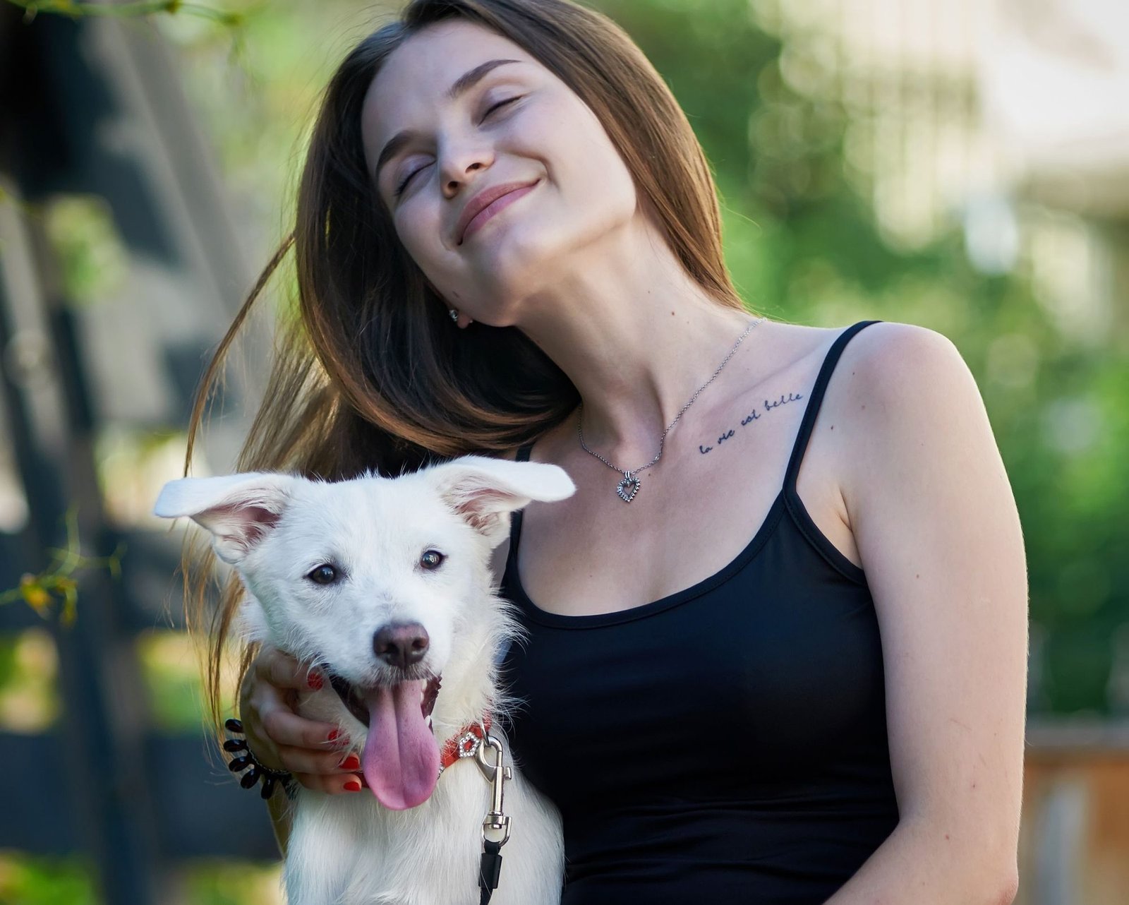 Pet parent with their arms around their dog in a backyard